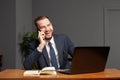 Happy smiling businessman wearing blue suit using smartphone in office. Successful employer to make a good deal Royalty Free Stock Photo