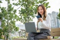 Young woman working laptop and using mobile smartphone outdoor building exterior Royalty Free Stock Photo