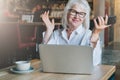 Happy smiling businesswoman sitting at table in front of laptop,holding hands up,working, learning. Royalty Free Stock Photo