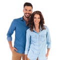 Happy smiling casual couple standing with hands in pockets Royalty Free Stock Photo