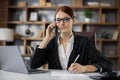 Happy smiling caucasian businesswoman sitting at desk with papers calling on phone Royalty Free Stock Photo