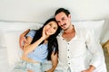 Happy smiling Caucasian couple lying on a comfy bed, relaxing and looking each other in the eyes and smiling. Romantic couple. Royalty Free Stock Photo