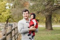 Happy smiling Caucasian father dad with cute adorable baby girl in ladybug costume. Family in an autumn fall park outdoor.