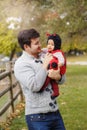 Happy smiling Caucasian father dad with cute adorable baby girl in ladybug costume. Family in autumn fall park outdoors. Halloween