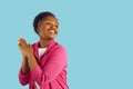 Happy smiling charming young african american woman with hands in pray gesture on blue background.