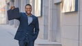 Happy smiling cheerful male African American businessman ethnic man worker entrepreneur at city street outdoors holding Royalty Free Stock Photo
