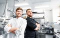 Happy smiling chef and cook at restaurant kitchen Royalty Free Stock Photo