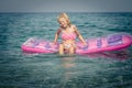 Cute girl sitting on inflatable pink airbed Royalty Free Stock Photo