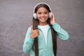 Happy smiling child enjoys listens to music in headphones. kid listen song outdoor. walking with favorite tune Royalty Free Stock Photo