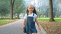 Happy smiling child girl in denim dress running in summer park on pavement path Royalty Free Stock Photo