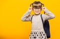 Happy smiling child girl in glasses is going to school for the first time. Child with school bag and with funny pigtails isolated Royalty Free Stock Photo