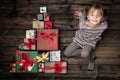 Happy smiling child girl in homewear keeping gift in vertical top view vintage wood with christmas tree pine made of Royalty Free Stock Photo