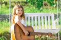 Happy smiling child girl play the guitar. Dreamy kids face. Smiling child playing outdoors in summer. Royalty Free Stock Photo