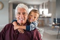 Happy smiling child hugging grandfather from behind Royalty Free Stock Photo