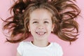 Happy smiling child portrait on the pink background. Little todler attractive lovely sweet curious cheerful girl laughs with her