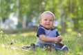 Happy smiling child seting outdoors in summer park Royalty Free Stock Photo