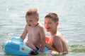 Happy smiling children playing in the sea. Summer vacation and active games on the beach