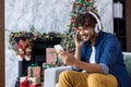 Happy smiling christmas man using phone watching funny video smiling and listening to online music, streaming podcasts Royalty Free Stock Photo