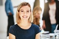 Happy, smiling and confident business woman sitting in a modern office, workspace or workplace. Portrait of a cheerful Royalty Free Stock Photo