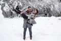 Man lifting girl in snow in forest Royalty Free Stock Photo