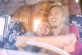 Happy smiling couple inside a vintage minivan - Travel people excited driving for a road trip with a van camper Royalty Free Stock Photo