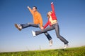 Happy smiling couple jumping in blue sky Royalty Free Stock Photo