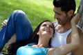 Happy smiling couple laying on green grass