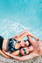 Happy smiling couple in love lying on the pool side Royalty Free Stock Photo