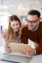 Happy smiling couple shopping online at home. Technology, e-commerce concept. Royalty Free Stock Photo