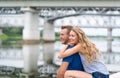 Happy smiling couple sitting on the bank of the river on summer and looking afar Royalty Free Stock Photo