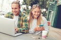 Happy smiling couple in street cafe, using phone and laptop Royalty Free Stock Photo