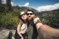 Happy smiling couple of students in love take selfie self-portrait while hiking in Yosemite National Park, California