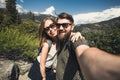 Happy smiling couple of students in love take selfie self-portrait while hiking in Yosemite National Park, California