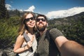 Happy smiling couple of students in love take selfie self-portrait while hiking in Yosemite National Park, California