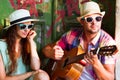 Happy smiling couple in sunglass and hat with guitar drinking j Royalty Free Stock Photo