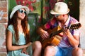 Happy smiling couple in sunglass and hat with guitar drinking j Royalty Free Stock Photo