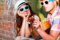 Happy smiling couple in sunglass and hat with guitar drinking j Royalty Free Stock Photo