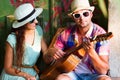 Happy smiling couple in sunglass and hat with guitar drinking j Royalty Free Stock Photo