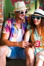 Happy smiling couple in sunglass and hat with guitar drinking j Royalty Free Stock Photo