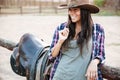 Happy smiling cowgirl in hat holding straw in mouth