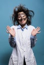 Happy smiling crazy scientist with messy hairstyle and dirty face acting innocent after dangerous explosion