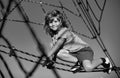 Happy smiling cute little child boy play monkey bars on the web in outdoor playground. Kids in rope park. Funny kids Royalty Free Stock Photo