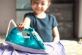 Happy smiling Cute little girl ironing a shirt at home. selecti Royalty Free Stock Photo