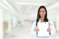 Happy smiling doctor holding clipboard standing in hospital hallway Royalty Free Stock Photo