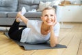 Happy smiling elderly old lady stretches hands to feet. Balancing yoga exercise for senior female Royalty Free Stock Photo