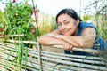 Happy elderly woman standing near wooden fence of vegetable garden Royalty Free Stock Photo