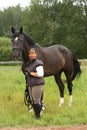 Happy smiling elderly woman and black horse portrait Royalty Free Stock Photo