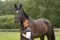 Happy smiling elderly woman and black horse portrait Royalty Free Stock Photo