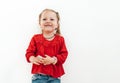 Happy smiling emotional little girl in red blouse on the white wall background