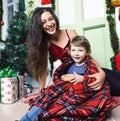 Happy smiling family on Christmas at house with gifts, young mother and little son in Santas red hat, lifestyle holiday